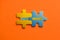Two colored details of puzzle with text Next Month on orange background, Yellow and Blue, close up