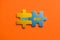 Two colored details of puzzle with text Next Page on orange background, Yellow and Blue, close up