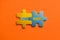 Two colored details of puzzle with text Next ussue on orange background, Yellow and Blue, close up