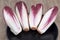 Two-colored endives in a black plate close-up