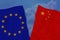 Two colored flags on torn fabric, a symbol of international relations between the European Union and China, the concept of global