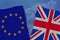 Two colored flags on torn fabric, a symbol of international relations of the European Union and Great Britain, the concept of