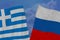 Two colored flags on torn fabric, a symbol of international relations between Russia and Greece, the concept of global business,