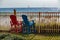 Two colorful Adirondack chairs await tourists wishing to enjoy the beautiful beach and gulf landscape and seascape