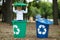 Two colorful boxes. Standing boy have fun inside recyling waste bin outside. Concept of environmental protection.