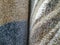 Two colorful brownish carpet rugs rolled for sale with closeup on their soft and fluffy warm texture pattern used as interior