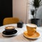 Two colorful ceramic coffee cups stand on a table in a vintage cafe with a delicious cappuccino and sweet latte. Good morning