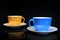 Two colorful cups of coffee on dark background
