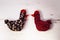 Two colorful knitted Easter hens, white wooden background