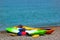 Two colorful sea kayaks with paddles and life jackets on stony beach