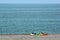 Two colorful sea kayaks with paddles and life jackets on stony beach