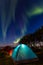 Two colorful sleeping tents under a night sky with green northern lights