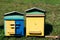 Two colourful wooden beehives.