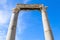 Two columns and portico fragment on blue sky background