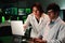 Two concentrated medical scientist with lab coat analyzing a pharmacy test with a laptop computer. A couple of a