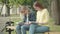 Two concentrated nerd female students in eyeglasses sitting on bench and reading books. Portrait of focused young