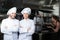 two confident chefs posing in professional kitchen