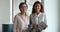 Two confident different aged business colleagues women standing in office