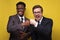 Two confident men in suit, african and caucasian guys making fist bumping