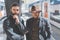 Two confident multi-ethnic bearded businessmans together wearing casual clothes and waiting the train on the railway