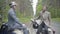 Two confident positive Caucasian men sitting on retro scooters on countryside and talking. Portrait of elegant