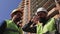 Two construction managers in helmets with a beard and mustache discuss construction details on the construction site.4k