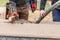 Two Construction Workers Pouring And Leveling Wet Cement Into Wood Framing