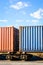 Two containers on a freight train parked in a rail terminal