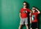 Two cool boys best friends in modern summer wear shorts, red t-shirt with prints and sunglasses posing together