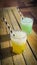 two cool cocktails with crasheis in green and yellow colors on the old wooden table in summer