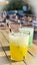 two cool cocktails with crasheis in green and yellow colors on the old wooden table in summer