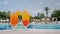 Two cool cocktails stand on the table on the background of the pool and palm trees. Paradise and luxury resort