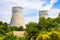 Two cooling towers of a nuclear power plant releasing vapor next to a plowed field