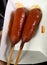 Two Corndogs covered in hot sauce