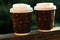 Two corrugated coffee cups on a wooden balcony. Hot drinks to go