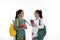 Two couple student talk together carrying bag and books in traditional clothes