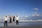 Two Couples, Arms Up Celebrating On Beach