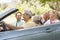 Two couples in convertible car smiling