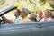 Two couples in convertible car smiling