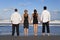 Two Couples, Holding Hands On A Beach