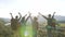 Two couples of young travelers waving at the top of a mountain.