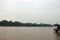 Two covered boats on the Tambopata River in Madre de Dios edged by the Amazonian rainforest