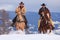 Two cowboys riding in deep snow