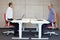 Two coworkers exercising on armchairs at workstations in office