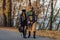 Two cozy smiling young girls walk at autumn park road