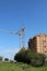 Two cranes build a house on the outskirts of the city on a summer day