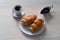 Two croissants on a plate with a cup of coffee and a saucer with