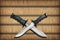 Two Crossed Blades Tactical Combat Hunting Survival Sawback Bowie Knives Set On Yellow Plaited Paper Parchment Place Mat Vignetted