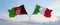 two crossed flags Afghanistan and Italy waving in wind at cloudy sky. Concept of relationship, dialog, travelling between two
