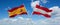 two crossed flags Austria and spain waving in wind at cloudy sky. Concept of relationship, dialog, travelling between two